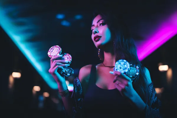 A young woman relaxing with her phone while dynamic casino elements float around her, illustrating the smooth mobile experience offered by the SZ777 app.