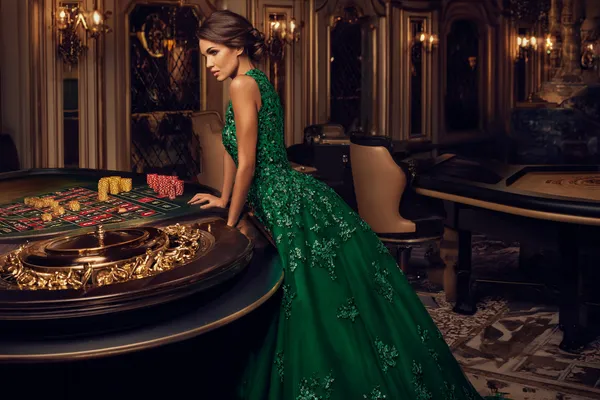 A woman in a luxurious green gown next to an ornate roulette wheel, capturing the upscale casino mood of SZ777.